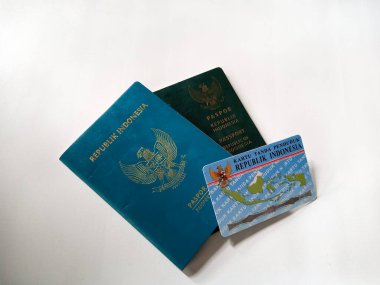 Beyaz arka planda iki Endonezya Cumhuriyeti yeşil pasaport ve Endonezya kimlik kartı.