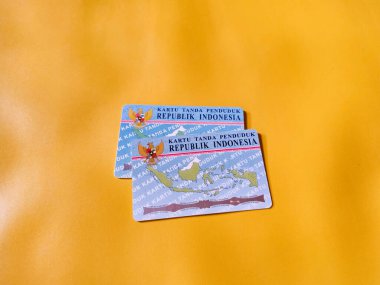 Endonezya kimlik kartının foto illüstrasyonunu kapat. KTP. Sarı geçmişi olan iki Endonezya vatandaşı kimlik kartı. Kimlikle ilgili konular için mükemmel.