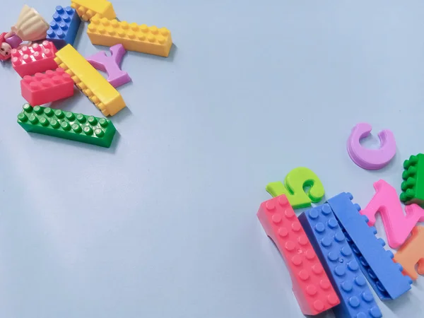 Çocuk oyuncakları geçmişi. Gökyüzü mavi arka planında renkli bloklar ve alfabe oyuncakları.