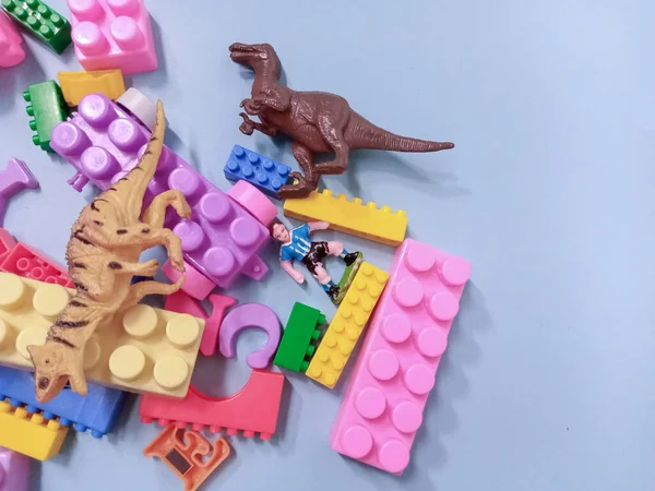 Çocuk oyuncakları geçmişi. Renkli bloklar, alfabe oyuncakları ve dinazorlar gökyüzündeki mavi arka plan çerçevesi.