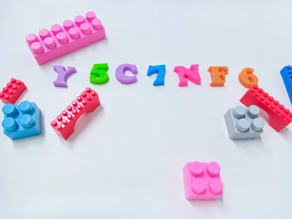 Kid Toys background. Colorful blocks, alphabet toys and Dinosaurs toys frame on white background.