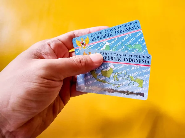 Mão Homem Segurando Dois Indonésios Cartão Identidade Cidadã Com Fundo — Fotografia de Stock