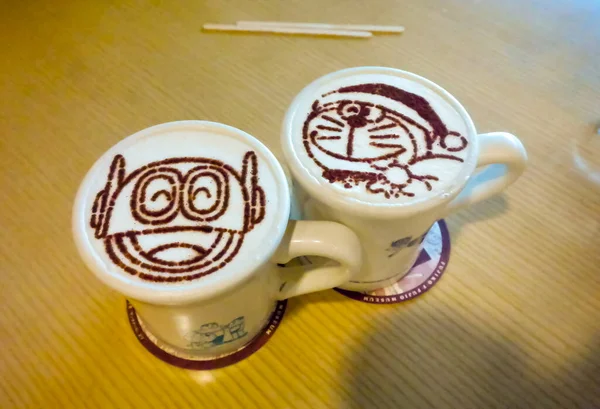 Japan 2015 11月19日 可愛いドラえもんアートのコーヒー豆をトッピングしたコーヒーラテのカップ — ストック写真