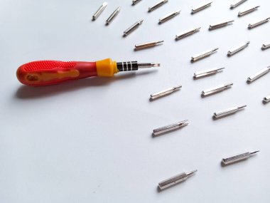 Çeşitli hortumları olan tornavida. Değişebilir tornavida seti. Farklı metal başlıklar ve beyaz arkaplanda izole edilmiş bitler..