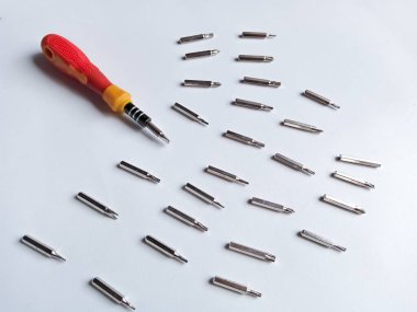 Çeşitli hortumları olan tornavida. Değişebilir tornavida seti. Farklı metal başlıklar ve beyaz arkaplanda izole edilmiş bitler..