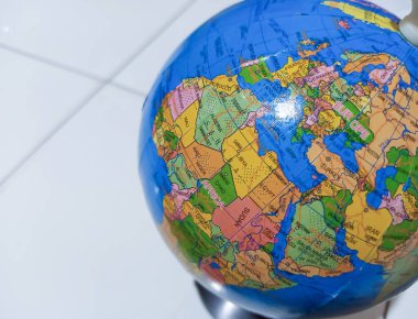 Beyaz arka planı olan küçük bir karasal küre. Afrika ve Avrupa Haritalarıyla Plastik Küreyi Kapat