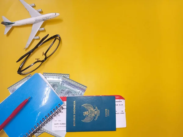 Pontianak 2022年12月27日 旅行コンセプト コピースペース付き黄色の背景にペン マレーシアリンギットのお金 パスポート 飛行機 チケット 三脚を旅行するための準備 — ストック写真