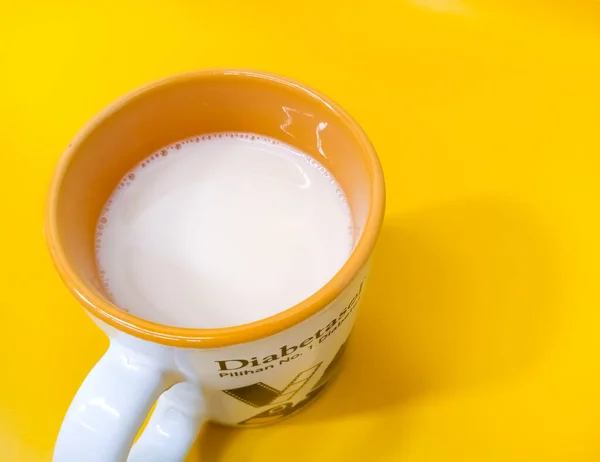 黄色の背景を持つガラス上の宗谷豆ミルクをトップビュー — ストック写真