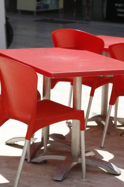 Sokakta kırmızı plastik sandalyeler