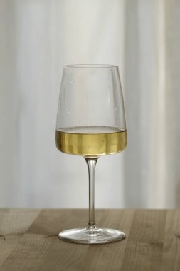 Arka planda bulanık bir şarap bardağı var.