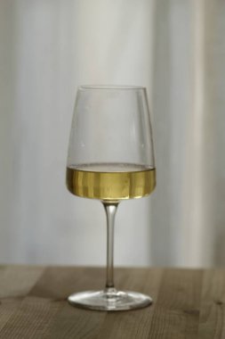 İçerideki masada bir bardak şarap. Ahşap arka planda şarap kadehi.