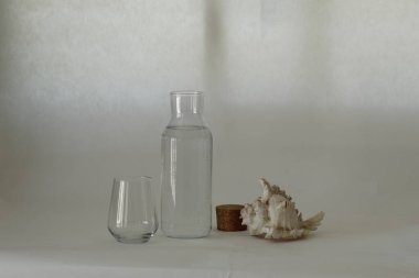 Beyaz bir masada bir şişe votka ve cam.