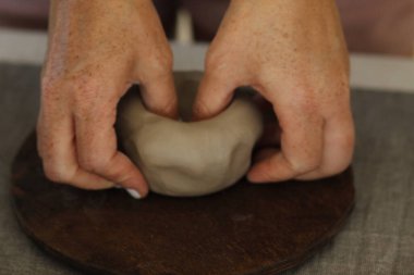 Kadın kilden demlik yapıyor.