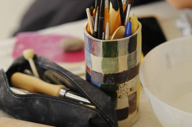 Atölyede ressamların el çizimleri ve fırçalar.