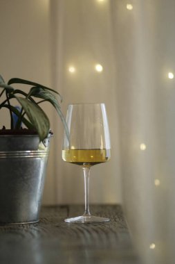 Bir bardak şampanya ve arka planda beyaz bir mum.