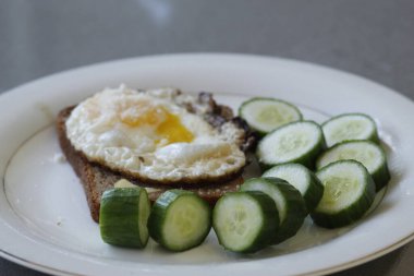 Yumurta, salatalık, salatalık, ekmek ve tereyağlı sağlıklı kahvaltı.