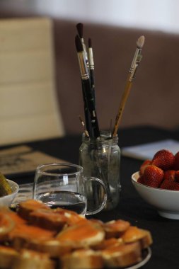 Bir fincan kahve ve bıçakla kahvaltı masasının dikey görüntüsü.