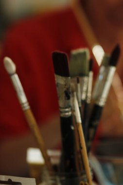 Sanatçı ahşap bir masaya resim çiziyor.