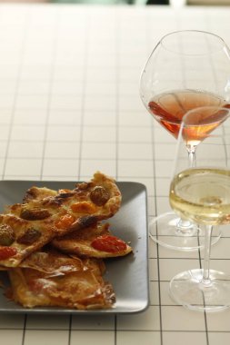 Şarap ve aperatiflerle dolu bardaklar.