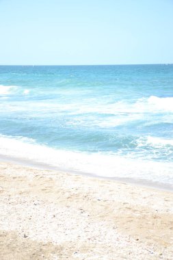 Güneşli bir günde güzel bir deniz manzarası ve kumsal.