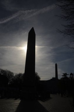 Theodosius Obelisk at the ancient Hippodrome near Sultanahmet, sun overhead and backlit, Istanbul, Turkey.