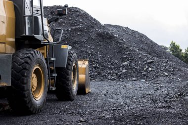 Construction of heavy equipment on the site on a coal dump, Excavator working in the coal storage clipart