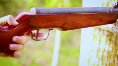 Hava silahıyla ateş eden bir adamın yakın çekimi, havalı tüfekle ateş eden bir adam.