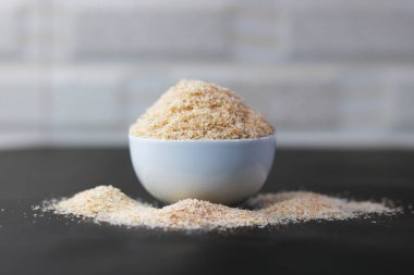 Siyah arka planda seramik kasede psilyum kabuğu (Isabgol)