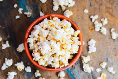 Eski ahşap masadaki pençe kasesinde tuzlanmış patlamış mısır.