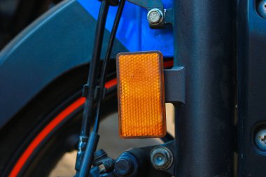 Arka planda bulanıklık olan bir motosikletin yan ışığına yakın plan.