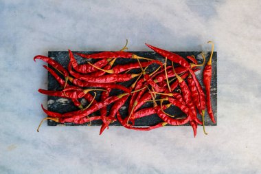 Beyaz arka planda siyah bilye üzerinde kırmızı biber..