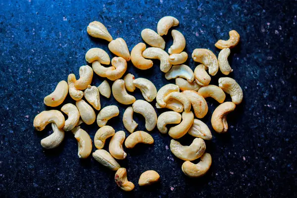 Siyah arka planda kavrulmuş kaju fıstığı. Ayarlanmış.