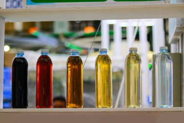 Bir tekstil fabrikasının rafında farklı renklerde plastik şişeler var. Tekstil renkleri