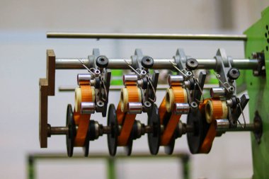 Bir fabrikada dönen makinenin üretim hattı, fotoğrafın yakın çekimi.