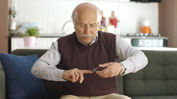 Evde Koltuğunda Oturan Yaşlı Bir Adam Tırnak Makası Ile Tırnaklarını — Stok fotoğraf