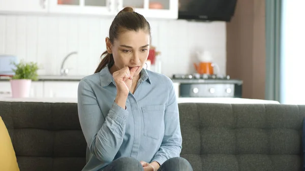 Nervous woman feeling panic, biting her nails, feeling anxious and confused. Frustrated and stressed woman waiting for someone at home. Angry woman biting her nails. Feelings of anxiety, fear.
