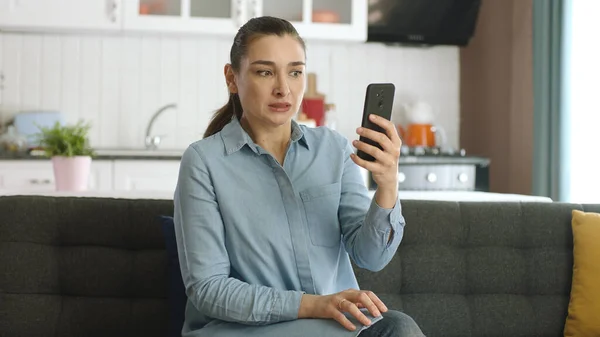 Attraktive Junge Frau Mit Smartphone Während Sie Auf Dem Sofa — Stockfoto