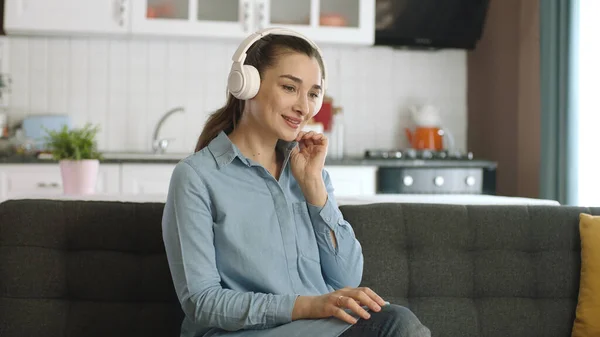 Νεαρή Ευτυχισμένη Γυναίκα Κάθεται Στον Καναπέ Στο Σπίτι Ακούγοντας Μουσική — Φωτογραφία Αρχείου
