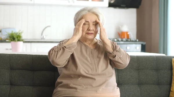 Stará Žena Pociťuje Silnou Bolest Hlavě Stařena Sedí Křesle Bolí — Stock fotografie