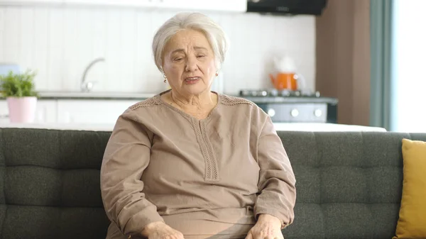 不幸而悲伤的老妇人躺在她宁静的家中的沙发上 那个白发苍苍的漂亮老妇人很不高兴 也很寂寞 — 图库照片