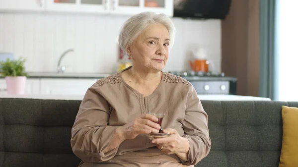 Mutlu Yaşlı Kadın Çay Içerken Televizyonda Ilginç Bir Film Izliyor — Stok fotoğraf