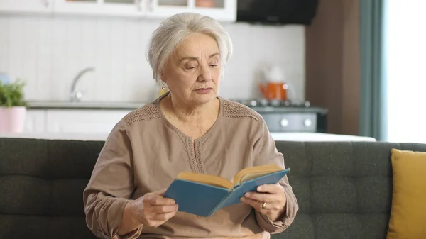 老年妇女在安详的家中看书 享受闲暇时光 快乐的老人 退休的女人的概念 爱看书的概念 — 图库照片