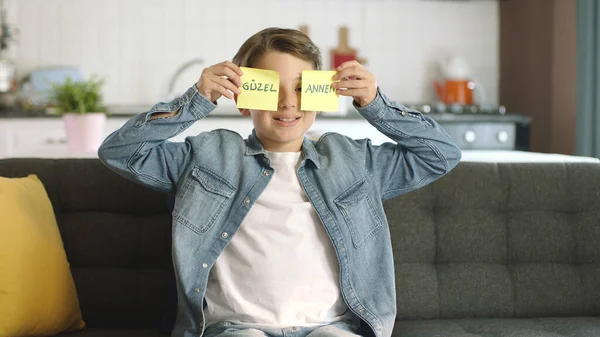 Little boy sending kisses. Mother\'s day, father\'s day, romantic concept.Message video of a happy kid holding paper notes with \