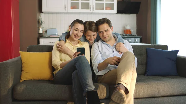 Счастливые Взрослые Родители Симпатичными Детьми Смотрящими Экран Телефона Развлекаясь Вместе — стоковое фото