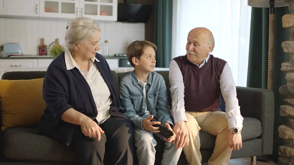 Kleine Jongen Bezoek Bij Zijn Grootouders Gelukkig Ouder Paar Zitten — Stockfoto