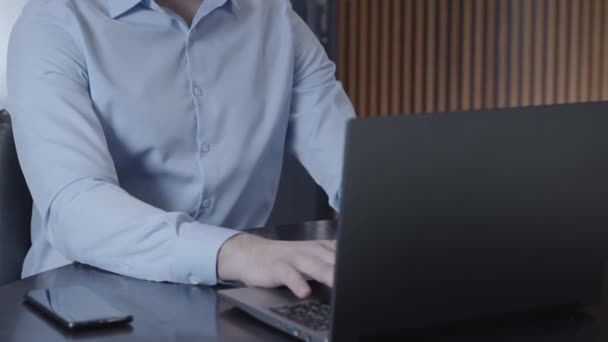 사무실에 책상에 스마트폰 있습니다 사무실에서 노트북으로 타이핑하는 남자의 클로즈업한 — 비디오