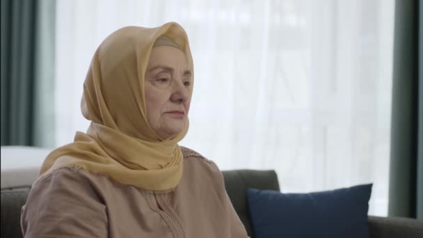 独坐家中或养老院的头戴头巾的老年妇女 独居的概念 — 图库视频影像
