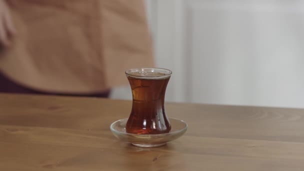 酒を注意してこぼした 地面にお茶を置く 彼女のゲストにトルコ茶を提供しながら お茶をこぼさないようにしようとする女性のクローズアップ手 — ストック動画