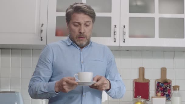 这个人在家里喝咖啡 他的咖啡洒了 那个洒咖啡的人很不高兴 — 图库视频影像
