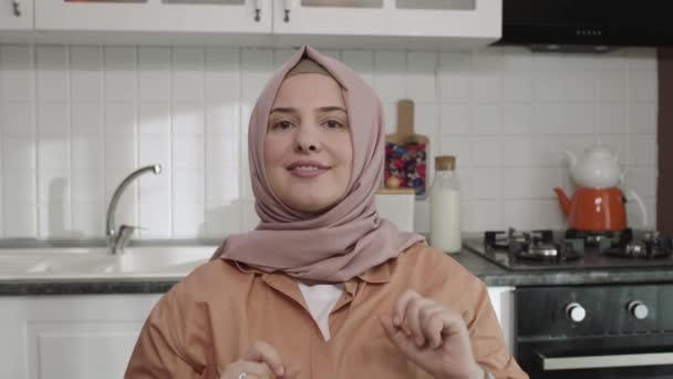 Kvinna Hijab Sitter Köket Gör Ram Gest She Tittar Kameran — Stockvideo